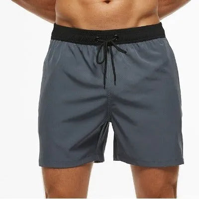 Men's blue drawstring fitness shorts with a zippered side pocket and stitching detail on the waistband.