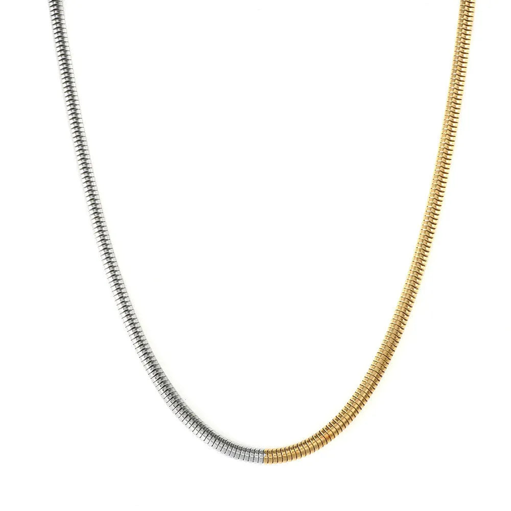 Close-up of a women's golden snake bones chain necklace with geometric lines, 3mm wide.