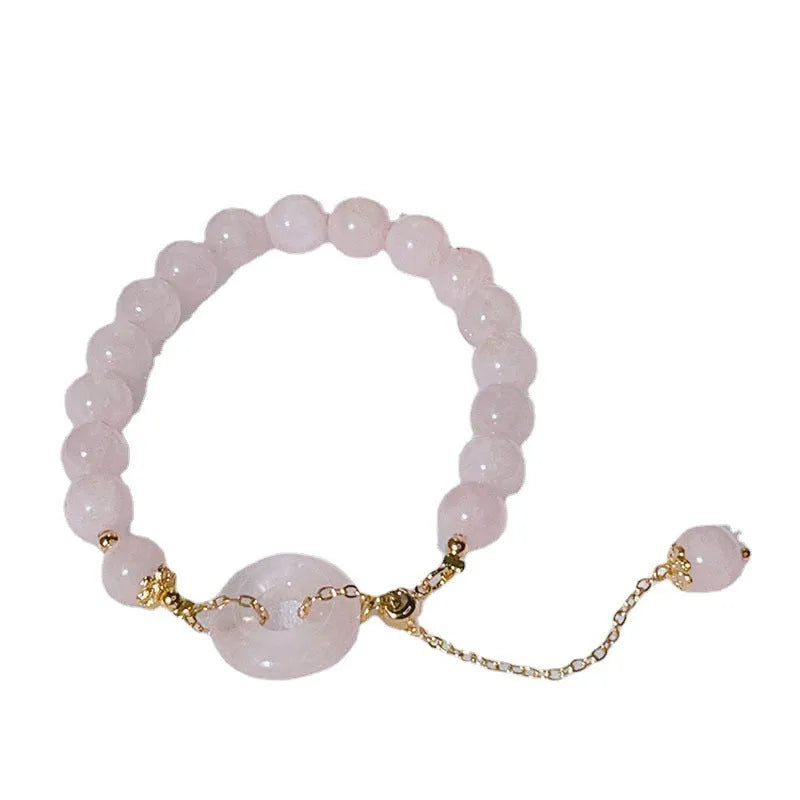 Pink crystal peace buckle bracelet on a metallic chain for women.