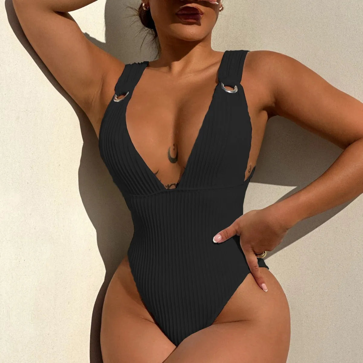 Women's solid colour one-piece swimsuit on a hanger, shown in black, white, green, and orange colour options.
