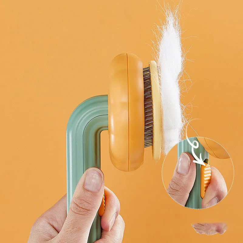 Pumpkin coloured pet grooming brush with curved stainless steel needles for hair removal