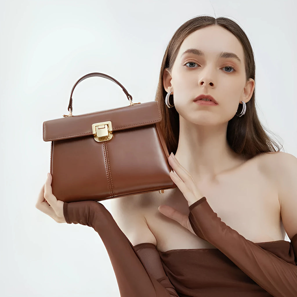 Black genuine leather women's shoulder bag with vachette clasp and long strap.