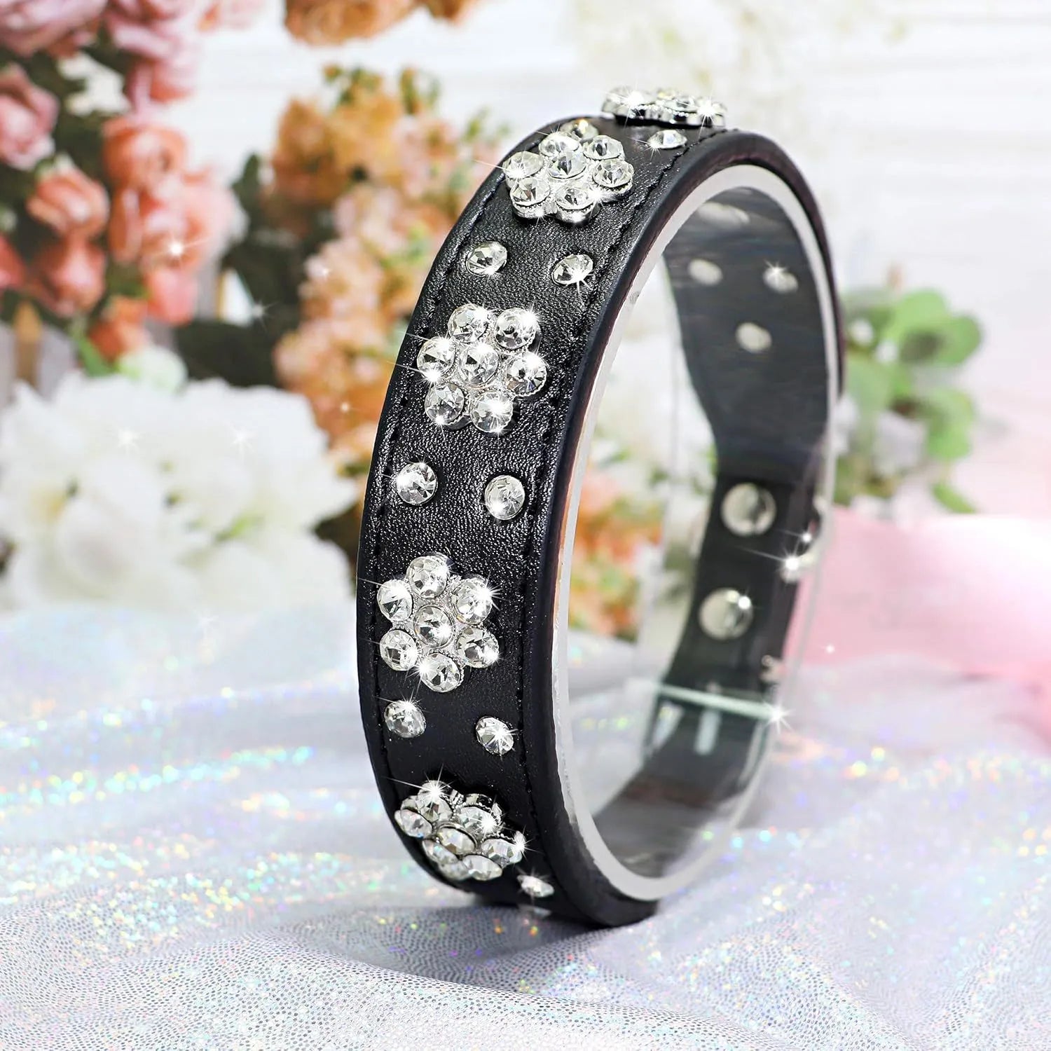 A studded rhinestone flower pattern on a soft black PU leather dog collar with a metal D-ring.