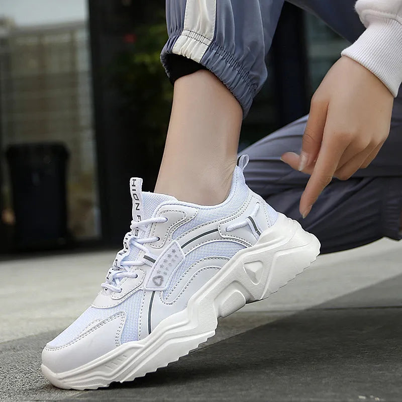 White women's casual sneaker with mesh upper, thick PU sole, buckle detail, and round toe.