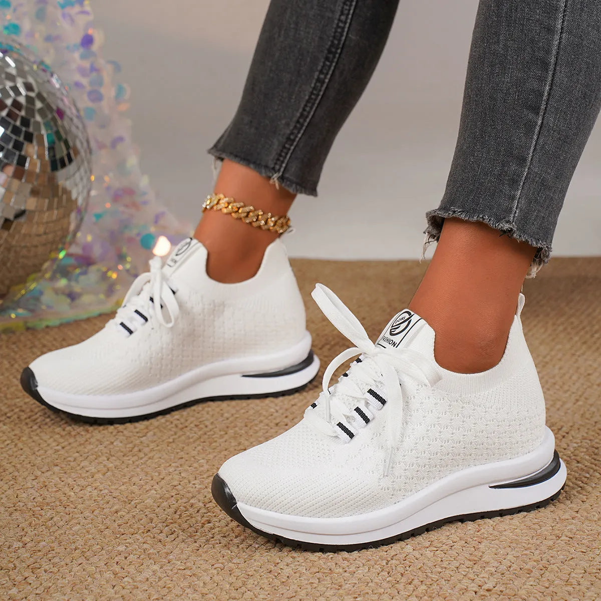 Women's black and white lace-up sneakers with mesh upper and flat rubber sole on a white background.