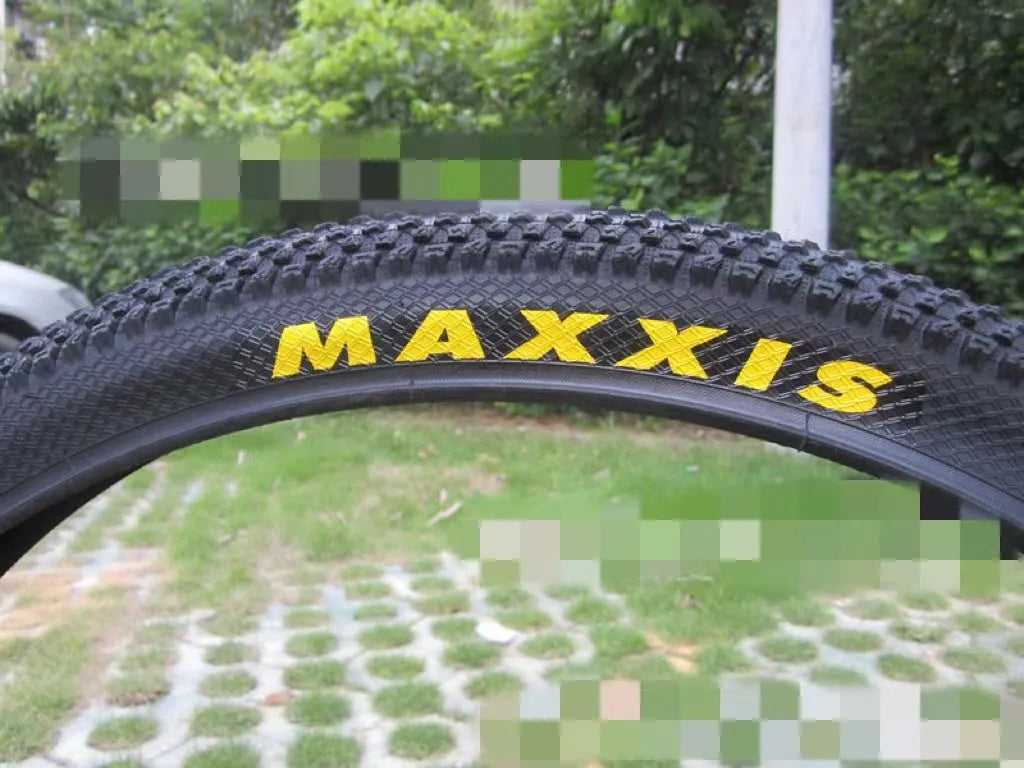 Ultralight puncture-proof mountain bike tyre in multiple sizes on a grey background.