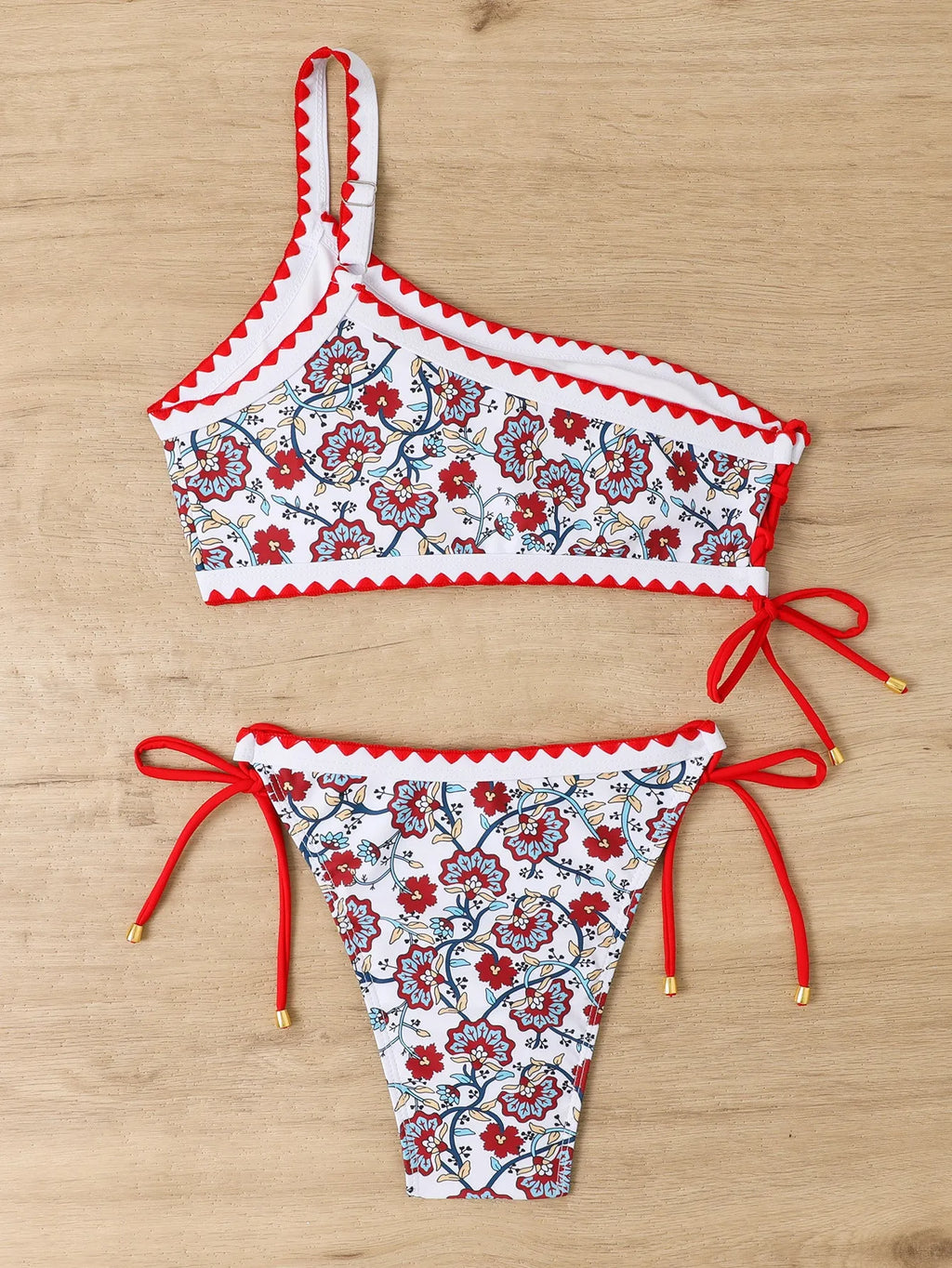 Blue and red one-shoulder floral bikini swimsuit for women laid flat.