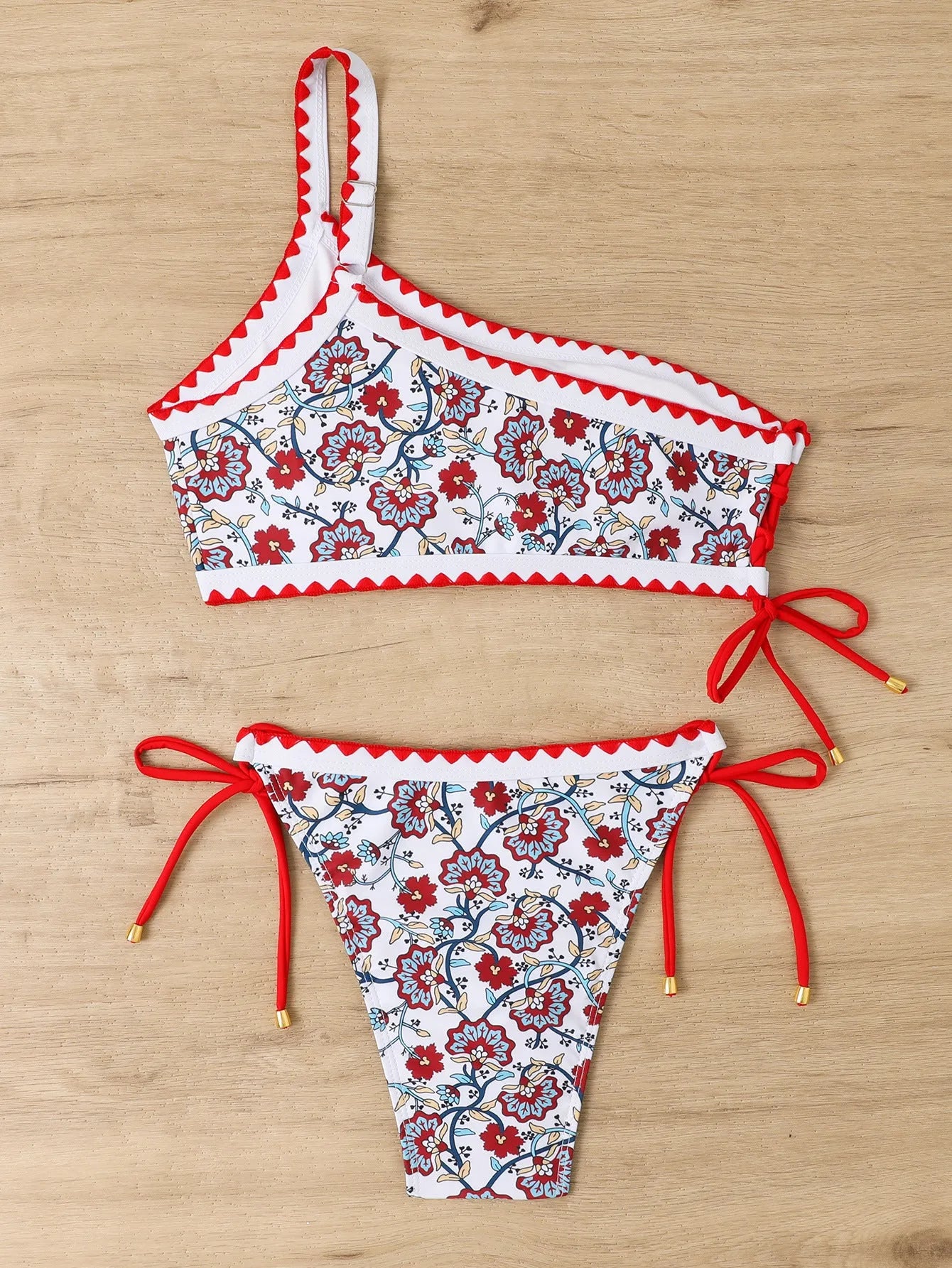 Blue and red one-shoulder floral bikini swimsuit for women laid flat.