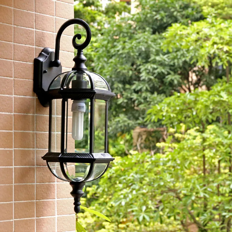 Outdoor aluminium wall lamp with three-layer design in black finish mounted on a courtyard wall