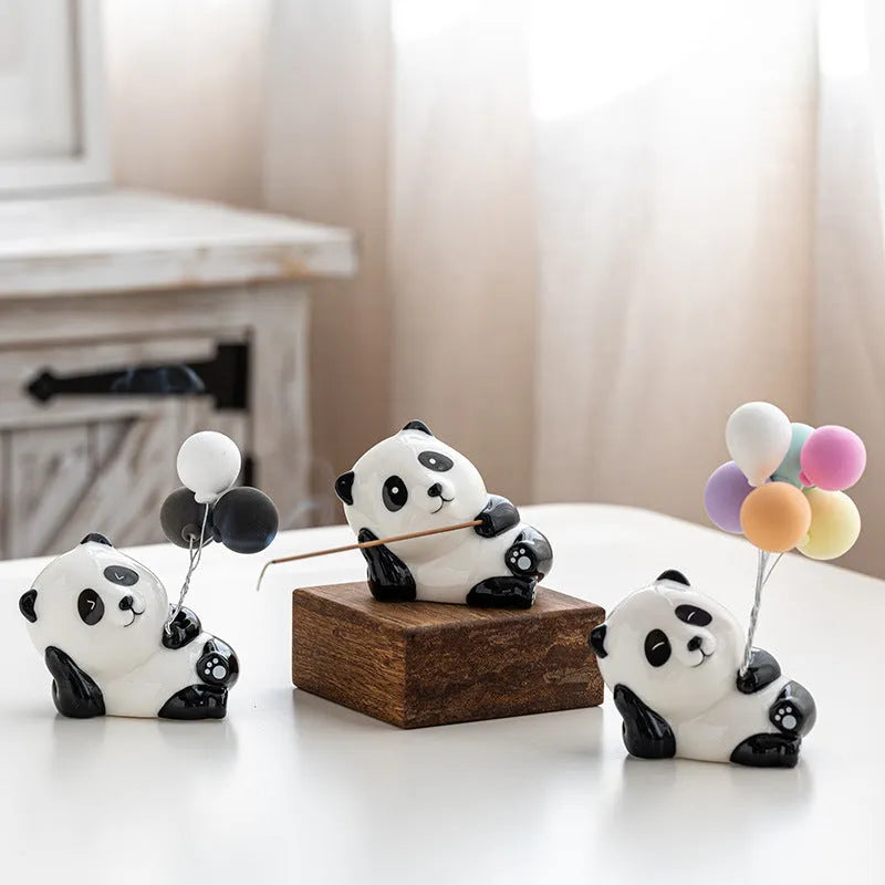 Ceramic panda incense holder in squinting style on a desk, 8.5cm high, with a lit incense stick