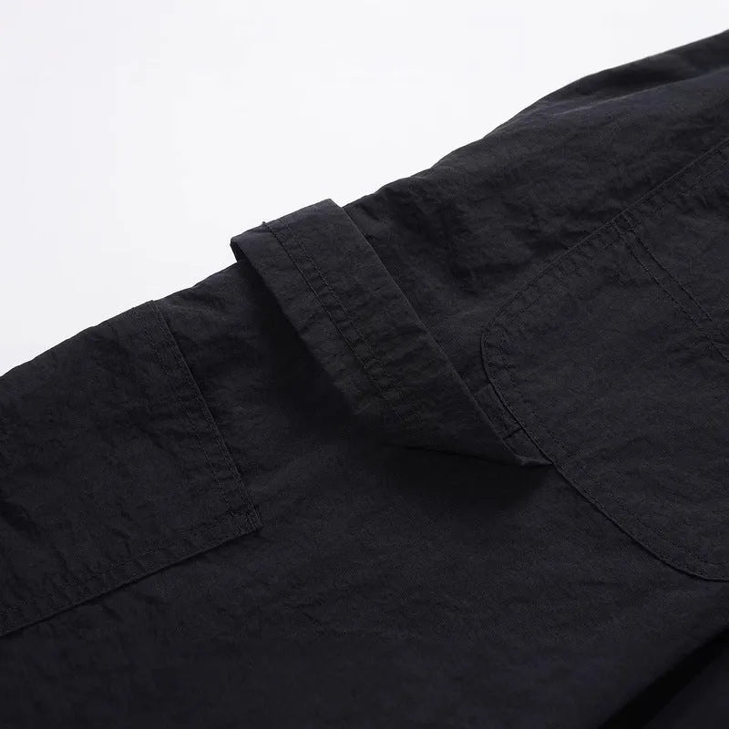 Black baggy paratrooper trousers with an elasticated drawstring waistband and three-dimensional cutting.
