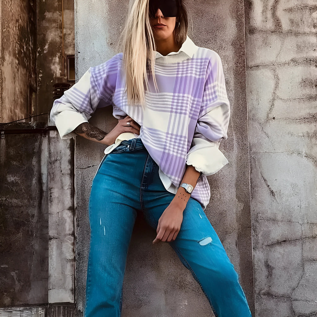 Loose lilac plaid print sweater with ribbed trim and long sleeves on a hanger.