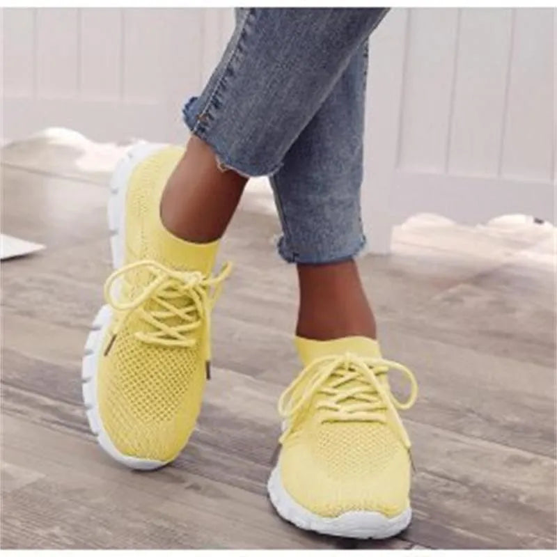 Breathable women's flying knit flat shoes in beige with mesh upper, round toe, low heel, and front tie closure.
