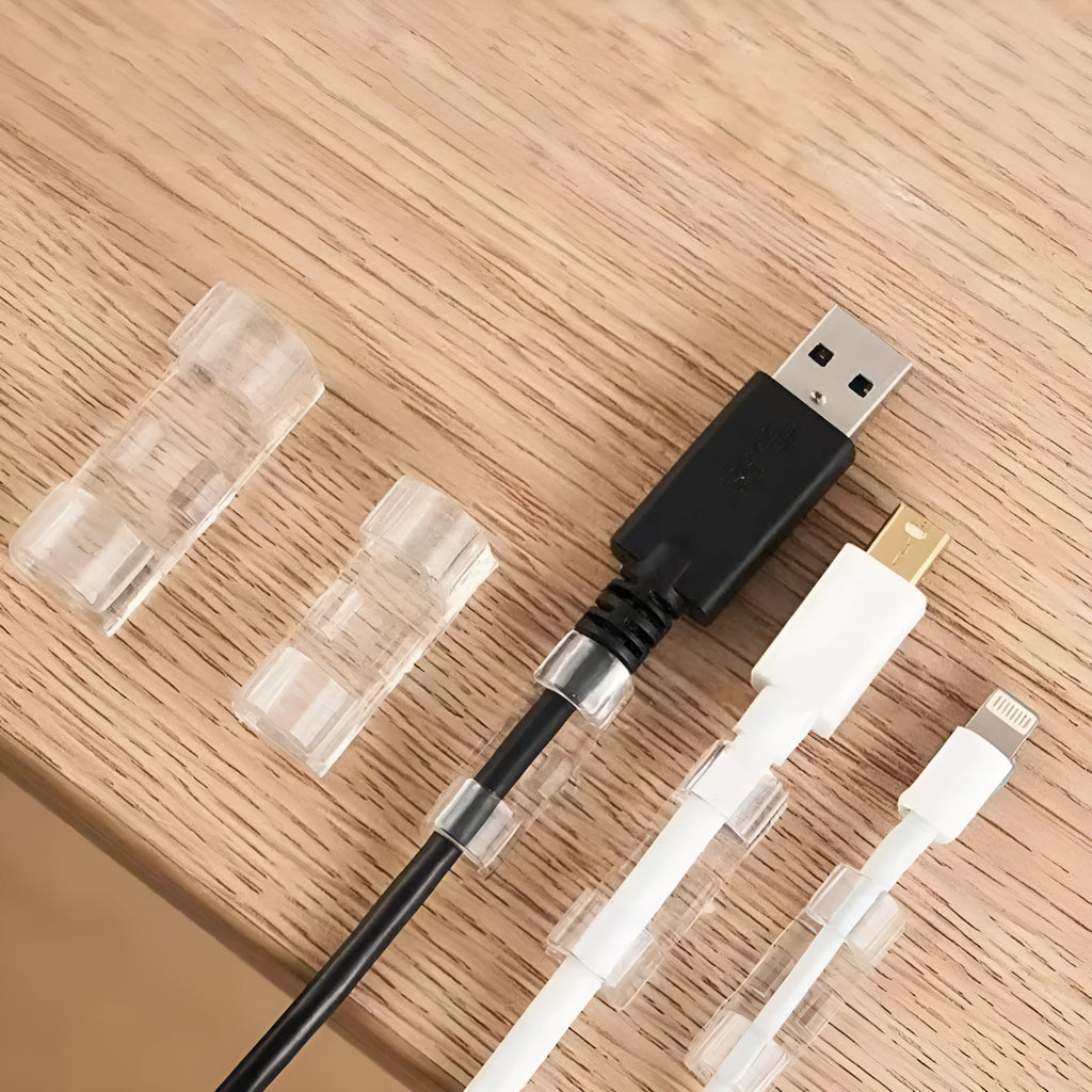 Transparent self-adhesive plastic cable management clips in four sizes on a white background.