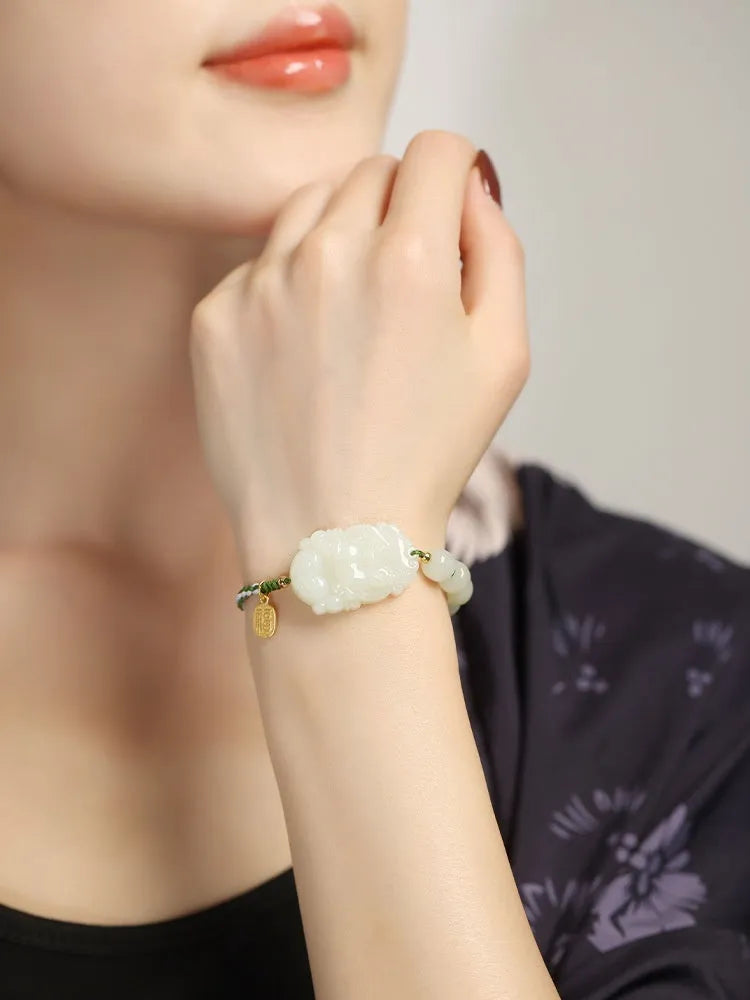 Year of the Rabbit red cord bracelet with Hetian jade charm and small silver blessing card.