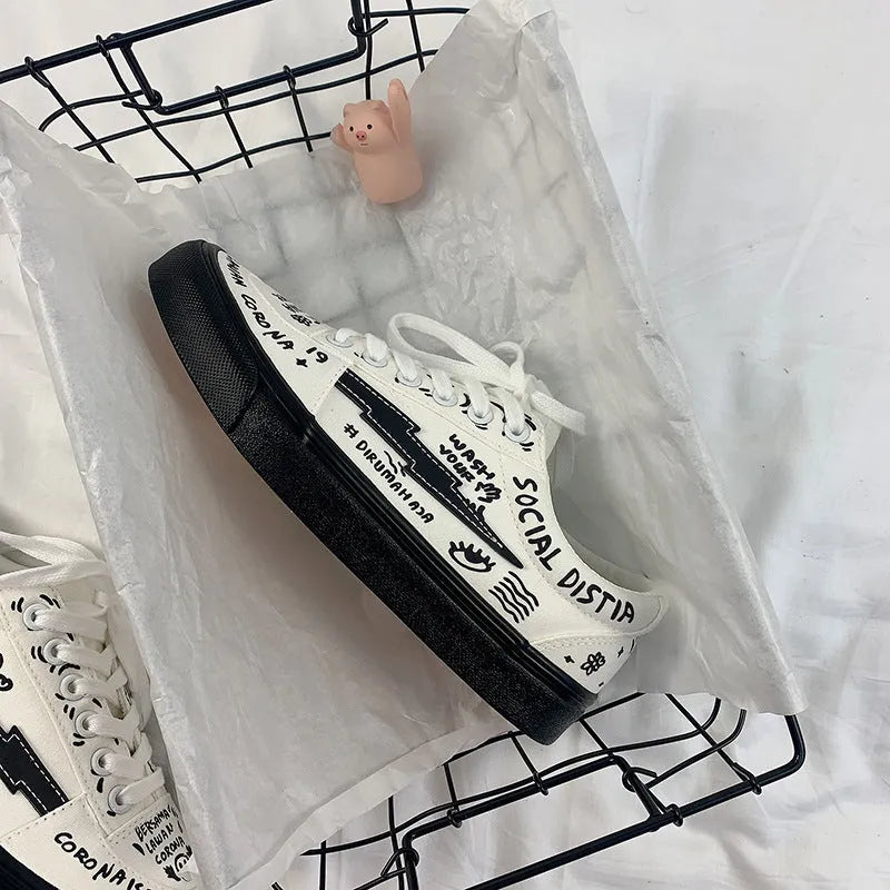 Women's white canvas shoes low top with lace-up tie and graffiti pattern on non-slip vulcanised sole