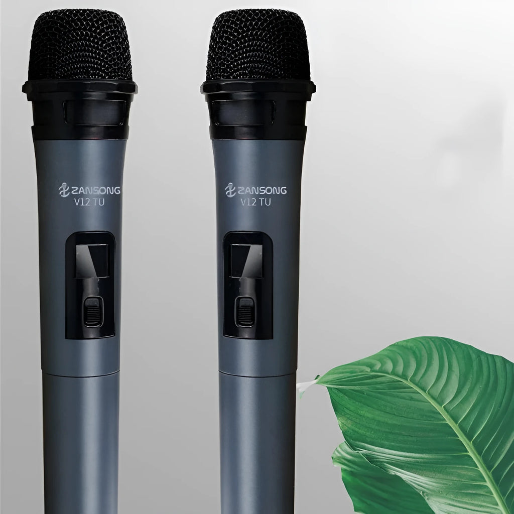 Black dynamic microphone with metal grill, USB receiver, adapter, and audio cable on dark background