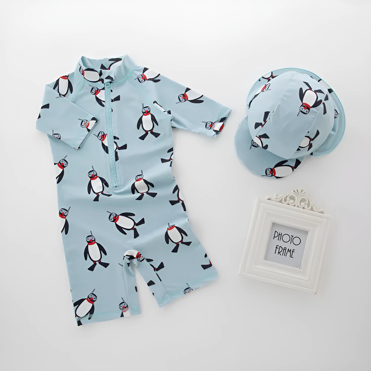 Boys' long sleeve penguin print swimsuit set with matching swim cap for sun protection.