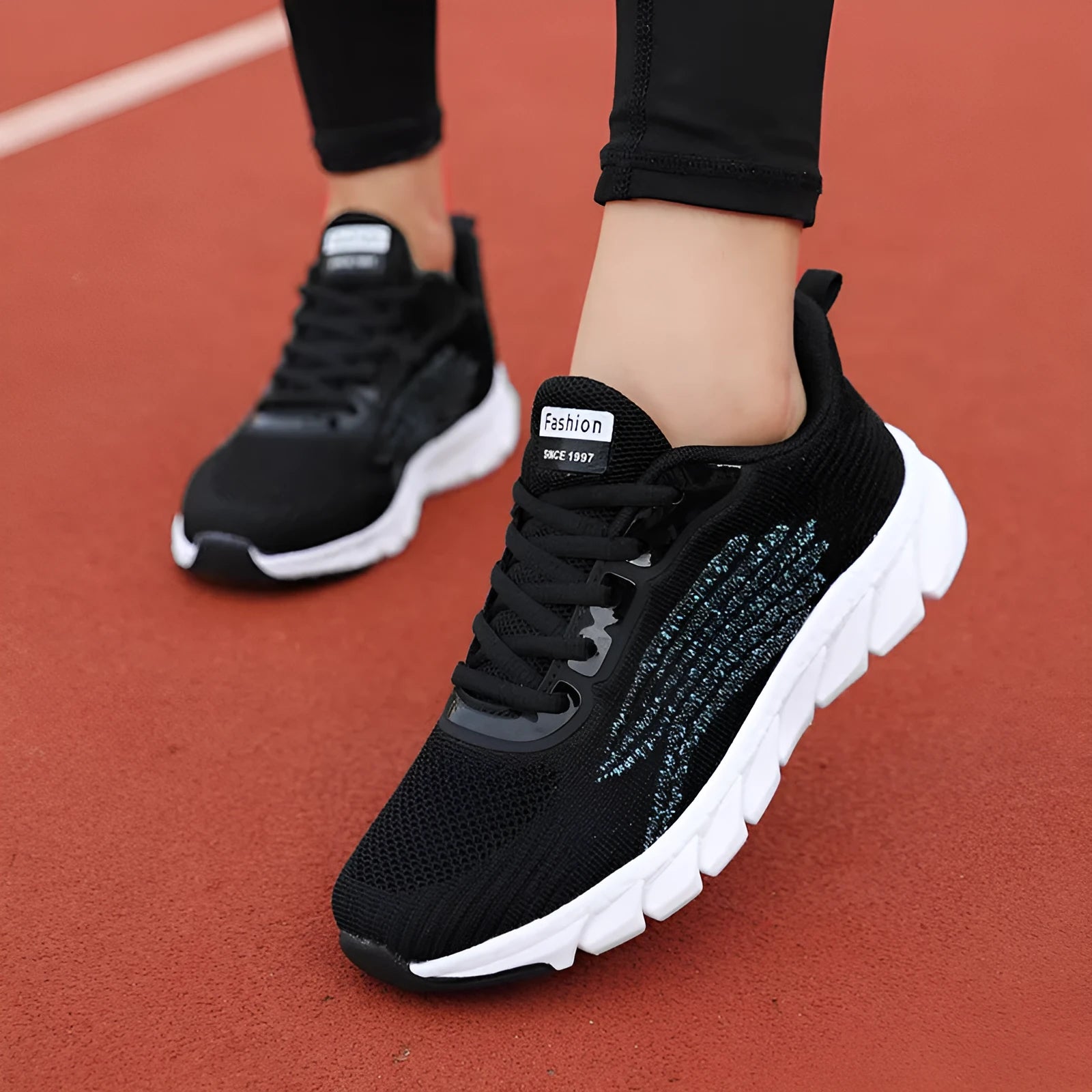 Women's low-top flat sneakers with cross-strap design in black and white colours