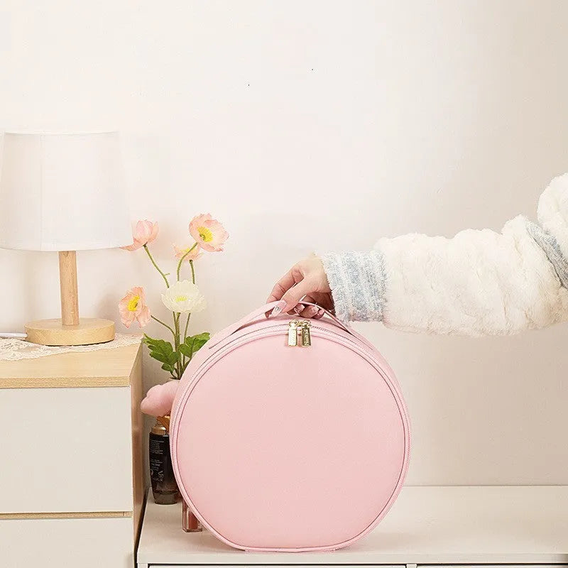 Round pink LED makeup bag open showing internal partitions and illuminated mirror.