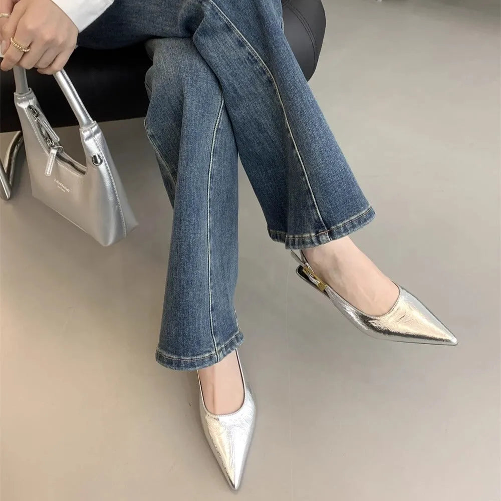Women's black low heel pointed leather court shoe with an ankle strap on a rubber sole.