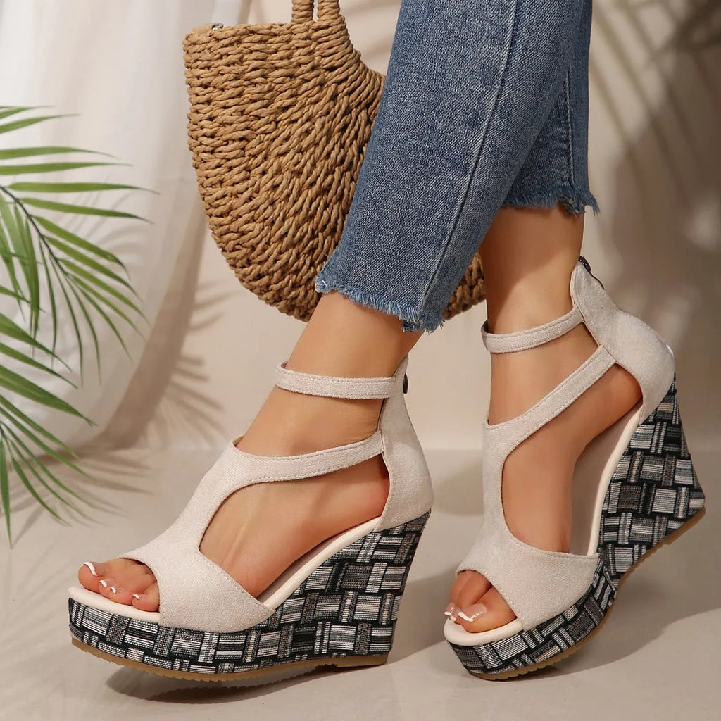 Women's beige wedge sandals with a thick rubber sole and buckle ankle strap on a cloth upper.