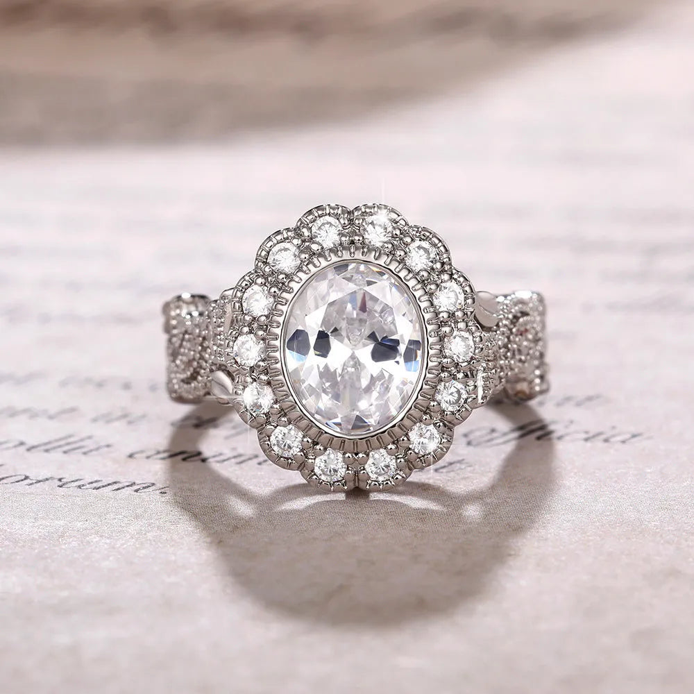 A geometric copper ring for women with a white gold coloured plating and a round zircon stone, shown on a finger.