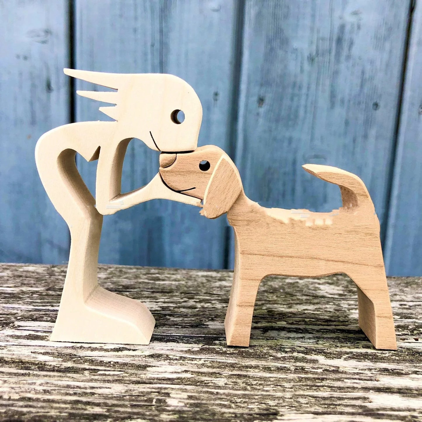 Handcrafted wooden dog sculpture featuring a man and his loyal canine companion