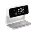 White 3-in-1 bedside lamp with wireless charging pad, LCD alarm clock screen, and touch-sensitive dimming control.