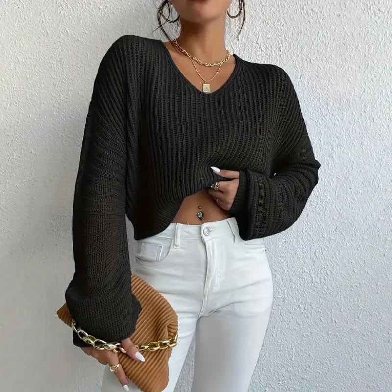 A woman wearing a solid colour long sleeve loose pullover top in a casual setting.