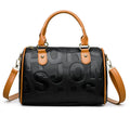 Cylindrical brown PU leather crossbody bag with three shoulder straps displayed