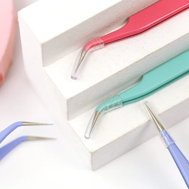 Stainless steel macaron-coloured tweezers in blue, green, and pink with straight and elbow tip styles on paper card packaging
