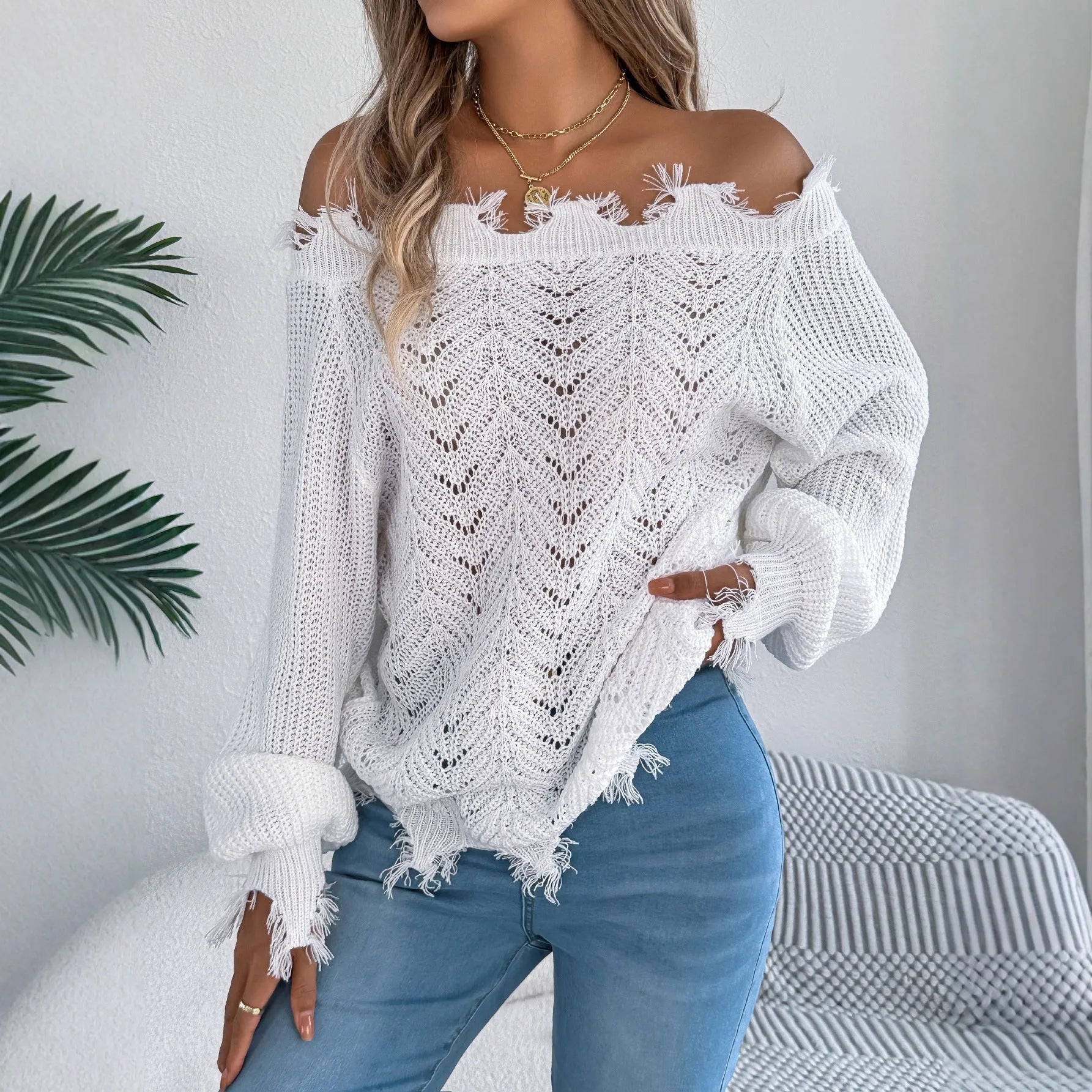 White cut-off shoulder pullover sweater with hollow-out detailing and long sleeves.