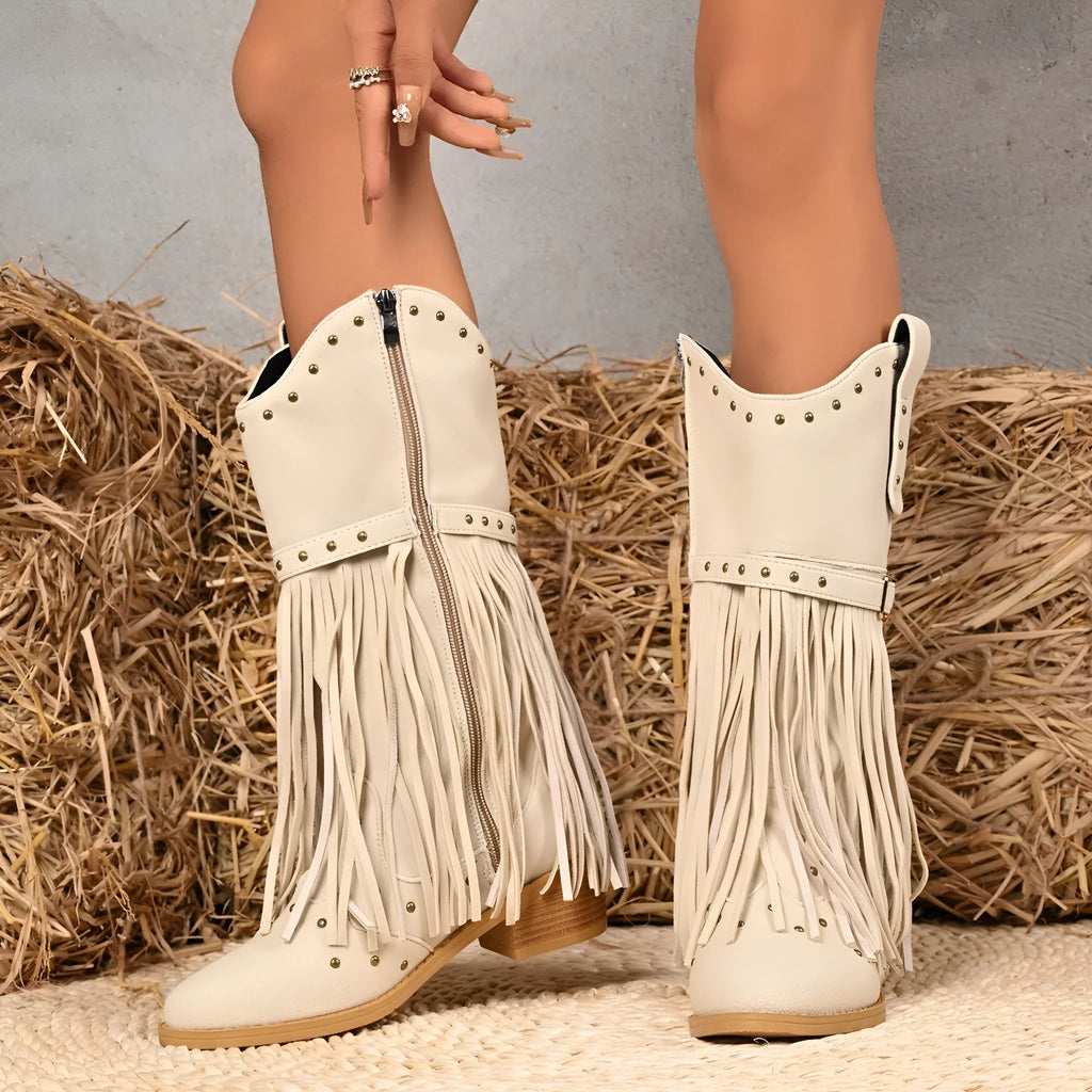Beige women's western cowboy boots with mid heel, side zipper, and tassel details on a white background