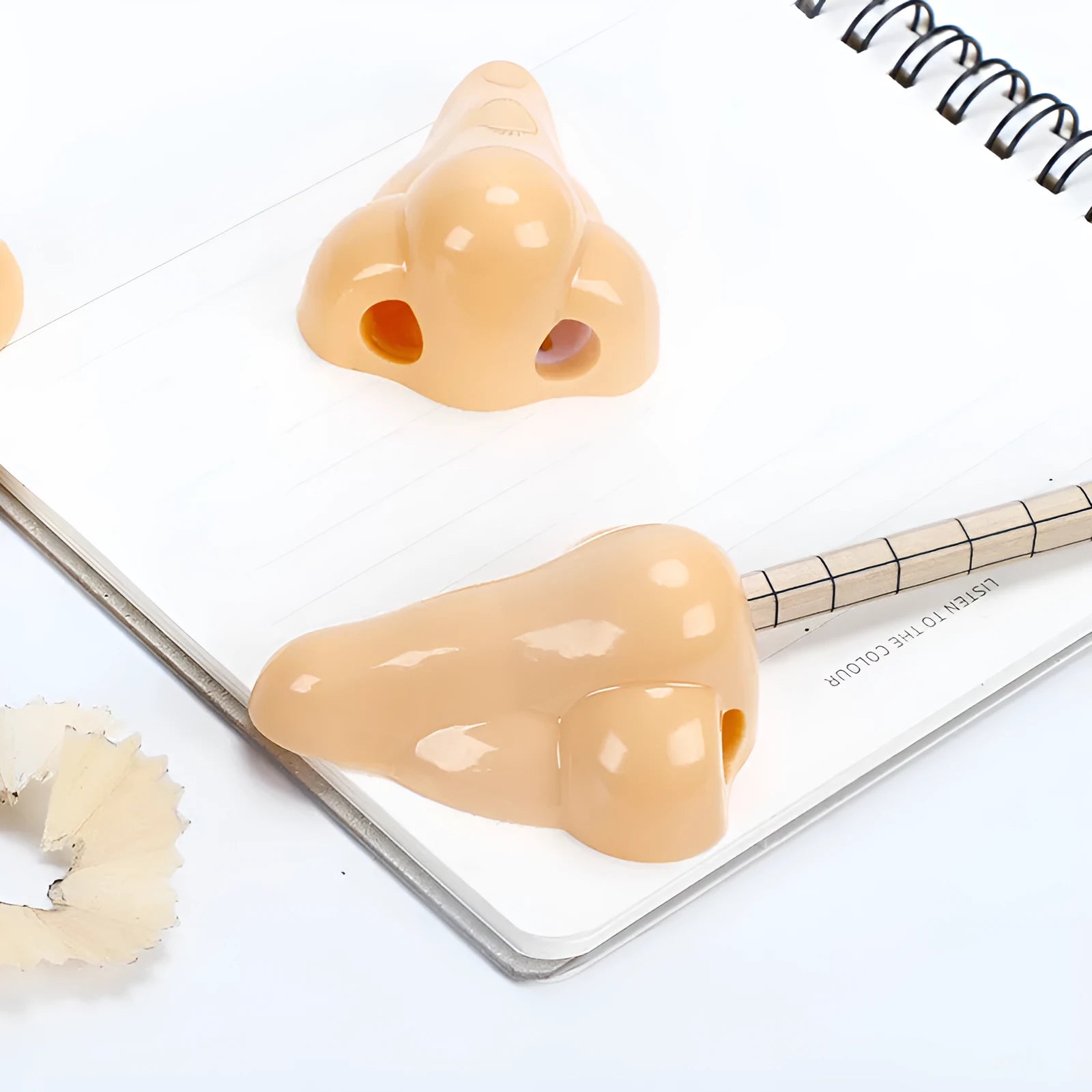 Flesh-coloured geometry-shaped plastic pencil sharpener with big nostril for standard pencils.