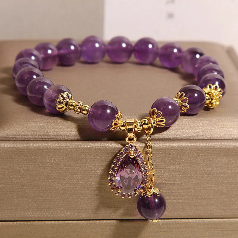 Natural amethyst bracelet with gold-plated inlay and purple droplet pendant on white background