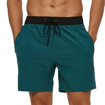 Men's blue drawstring fitness shorts with a zippered side pocket and stitching detail on the waistband.