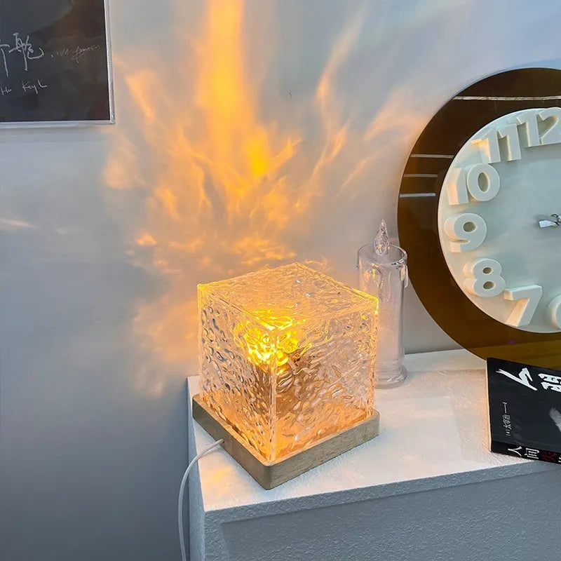 LED water ripple projection night light with remote control on wooden surface