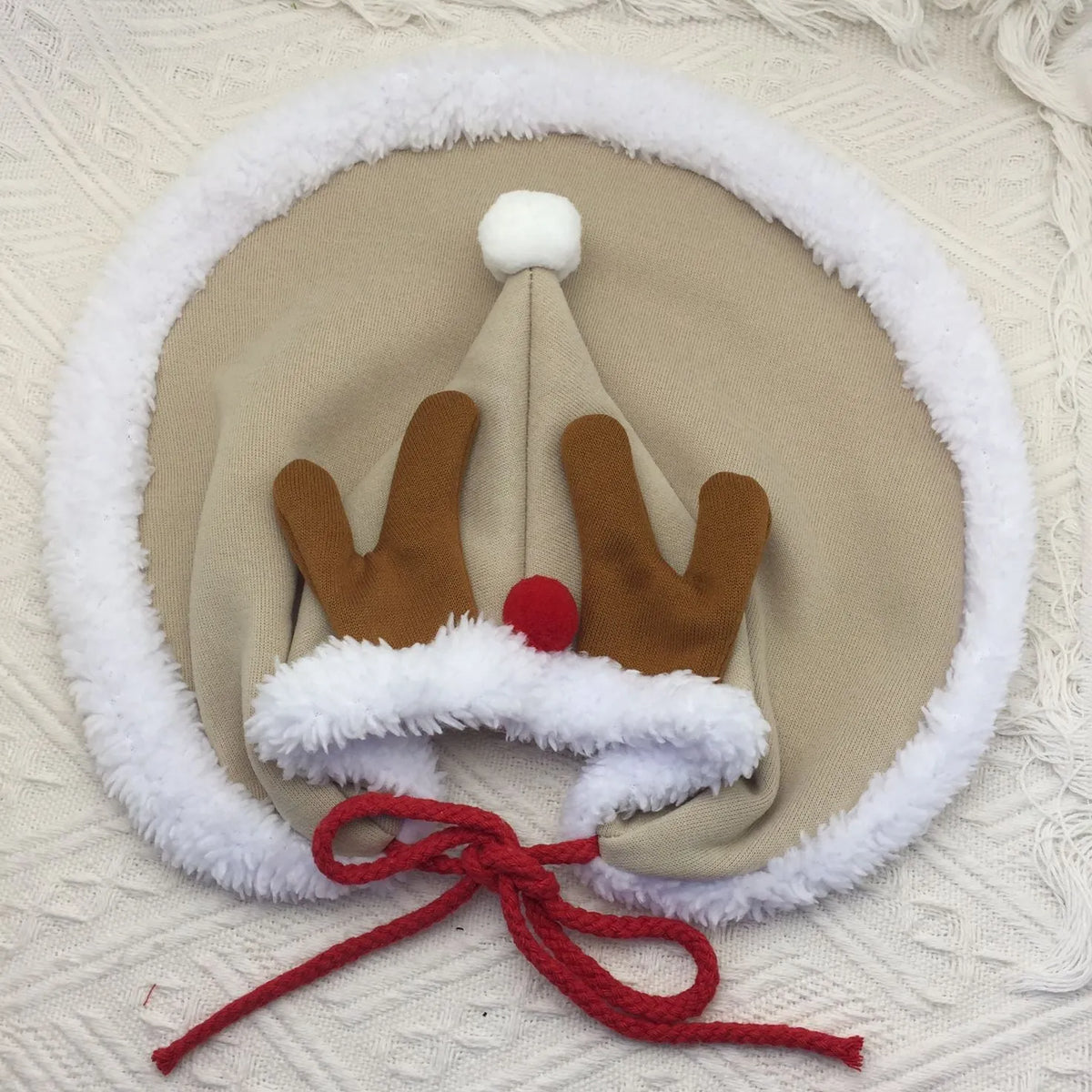 Cat wearing a velvet Christmas cape with star pattern and matching hat in brown, with adjustable tie rope visible