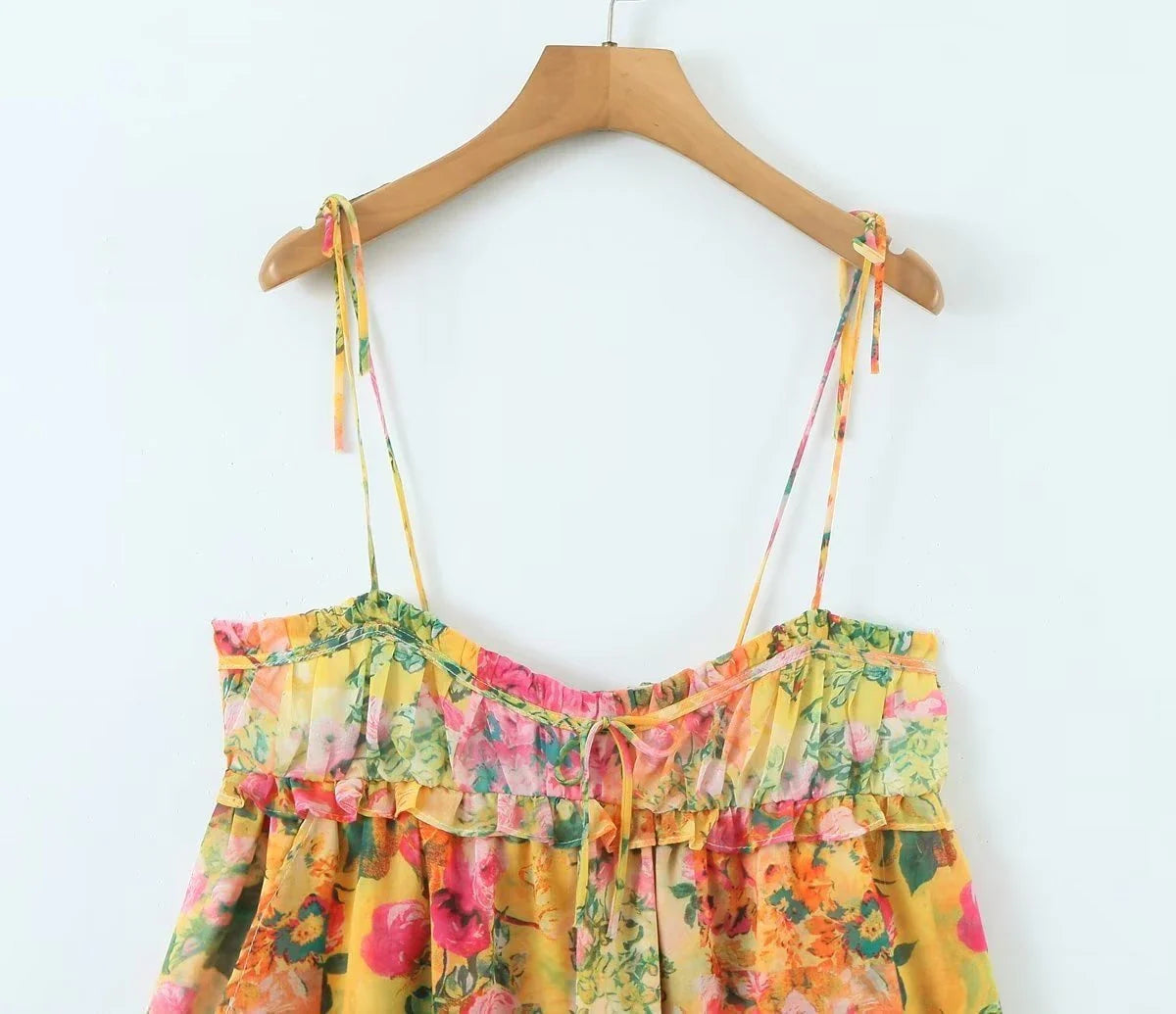 Stylish floral suspender dress with adjustable straps and playful ruffles, perfect for summer fun and fashion