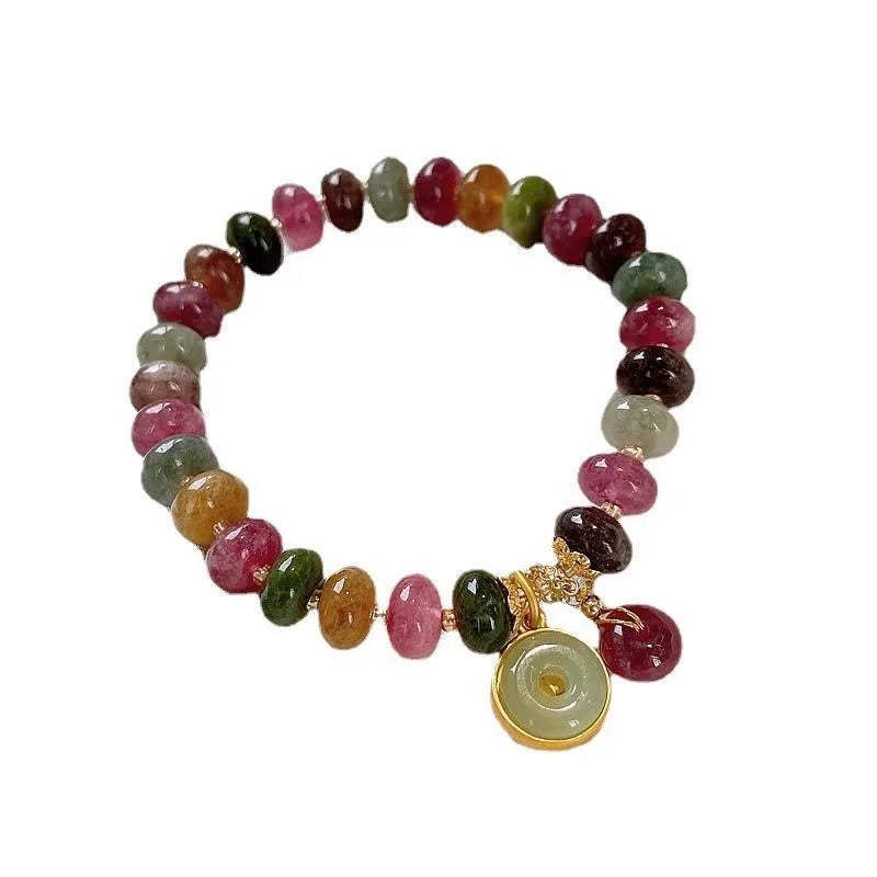 Colourful tourmaline beaded bracelet with geometric abacus beads and a rabbit pendant on a white background.