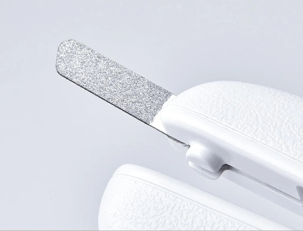 White pet nail clippers with LED light, transparent guard, and nail file on a grey background.