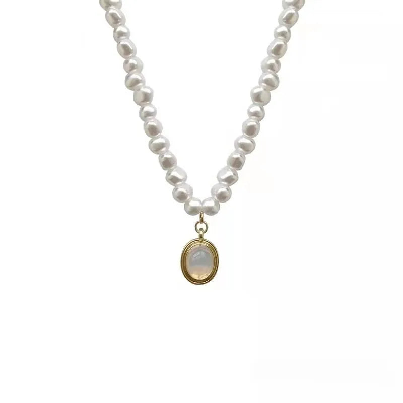 Vintage geometric pearl necklace with an adjustable chain from 21cm to 50cm on a grey background.