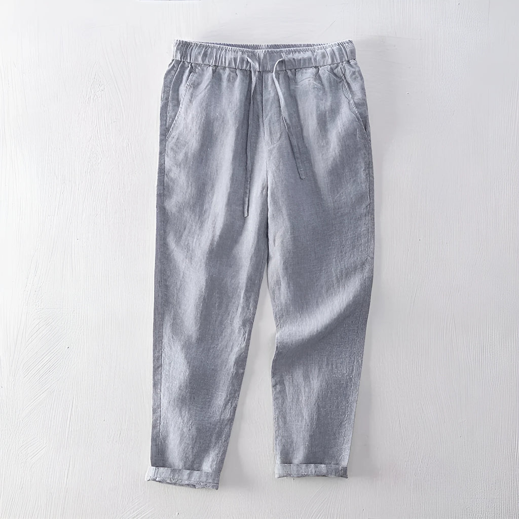 Men's straight-leg linen trousers in dark grey laid flat, showing mid waist and relaxed fit