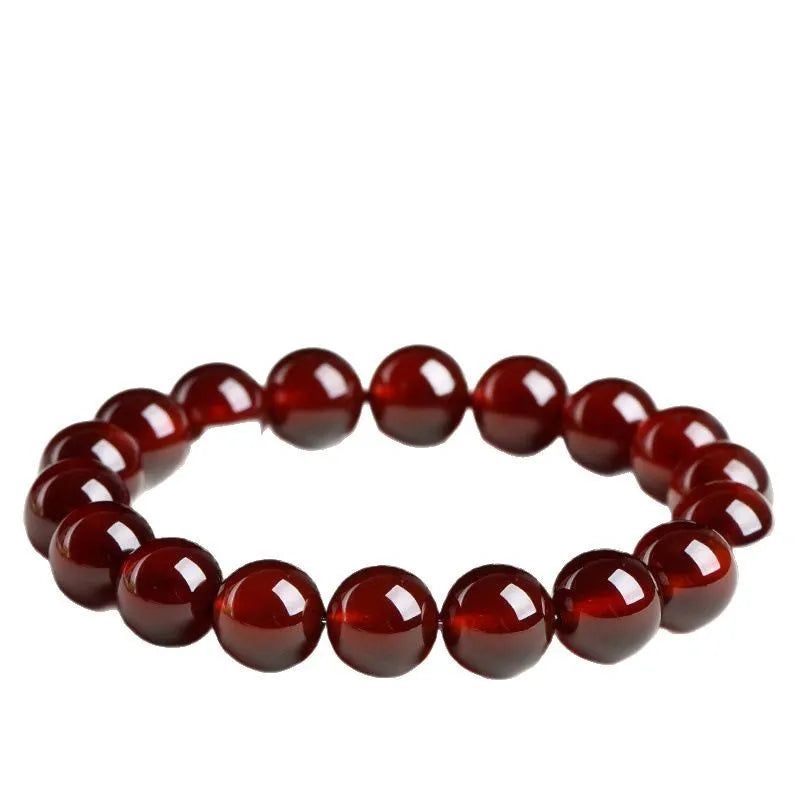 Natural orange red garnet ball crystal bracelet with a silver ruyi charm on a white background.
