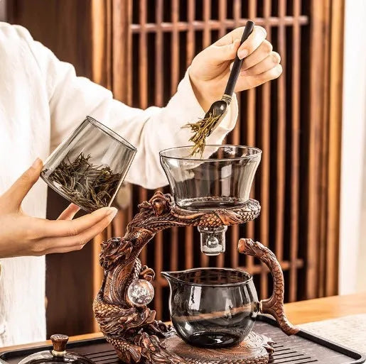 Green gray walnut glass automatic tea set with bowl, base, and fair cup on a table