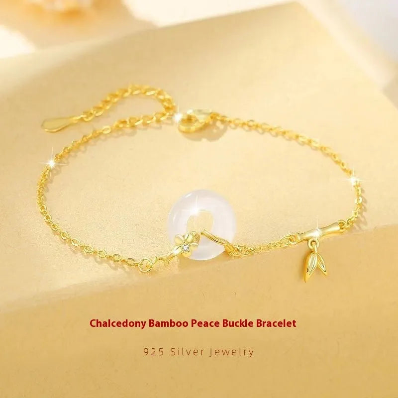 Gold-coloured women's silver bracelet with a peace buckle design and white chalcedony stone centrepiece.
