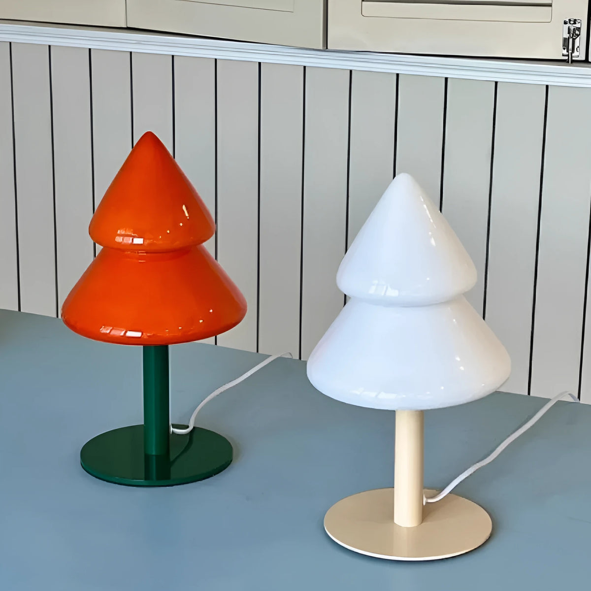 Colourful Christmas tree table lamp with glass lampshade and wrought iron base on a side table