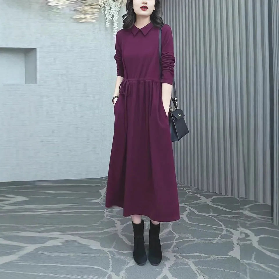 Purplish red women's plus size long sleeve dress with a long skirt on a hanger.