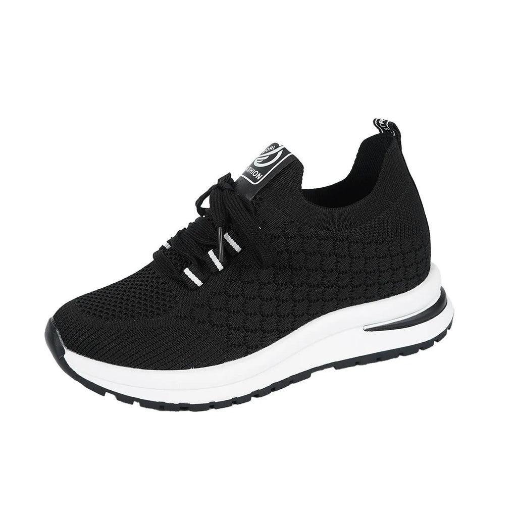 Women's black and white lace-up sneakers with mesh upper and flat rubber sole on a white background.